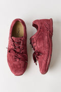 A pair of low-top suede sneakers in a dusty rose or muted burgundy color, shown from a top-down view on a clean white background. The brand name 'LONGINES' is visible on the insole.